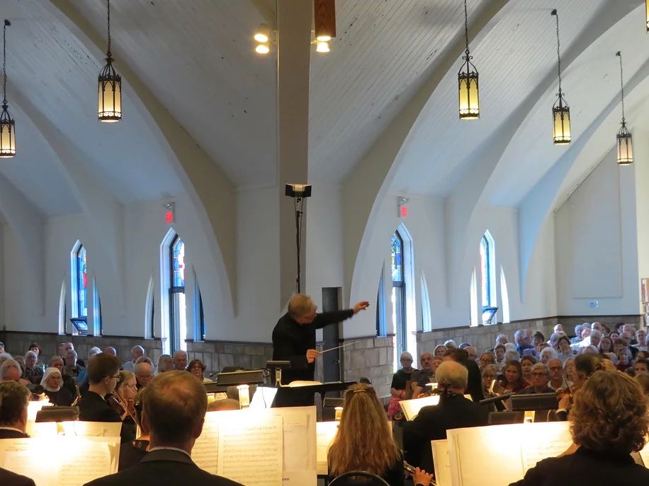 music director conducting orchestra in a church