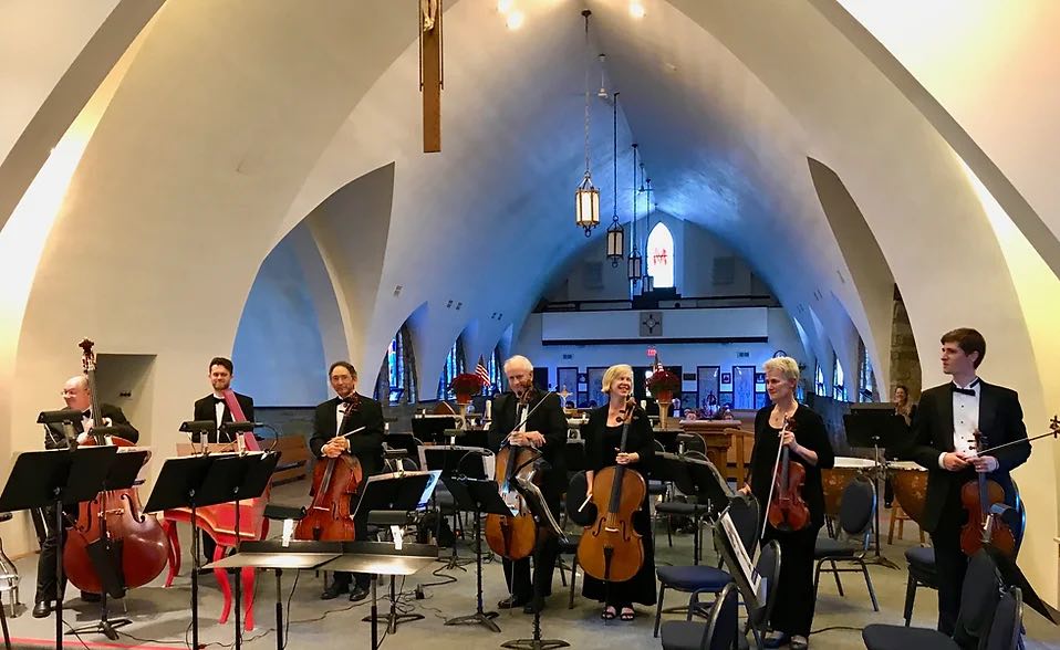 seven members of the orchestra standing with instruments