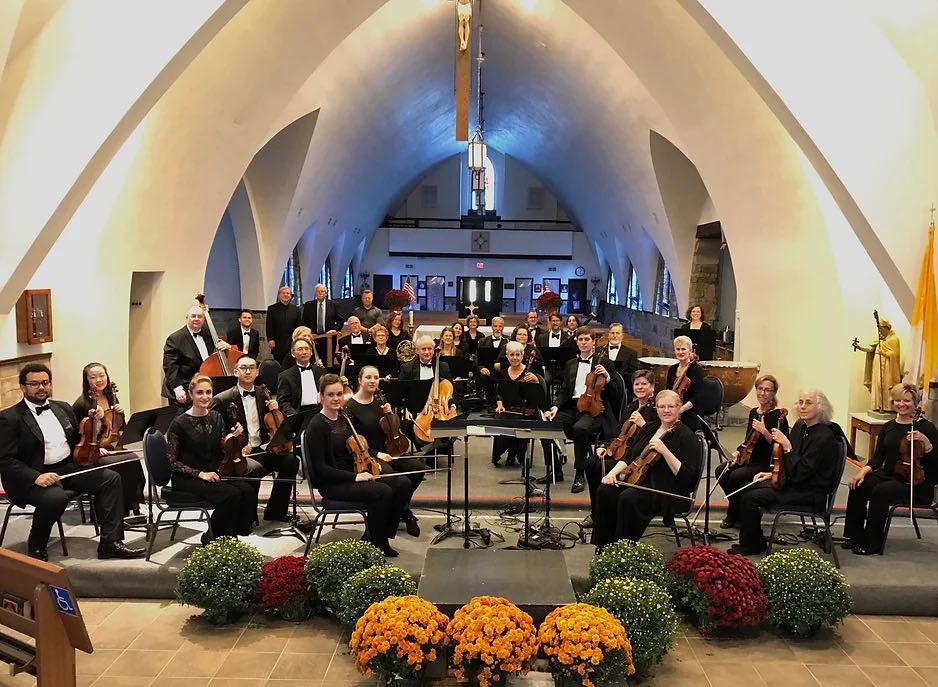 full view of an orchestra playing in a high ceilinged church