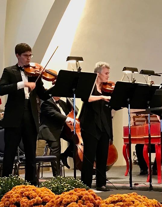 violinist and cellist playing and looking at sheet music