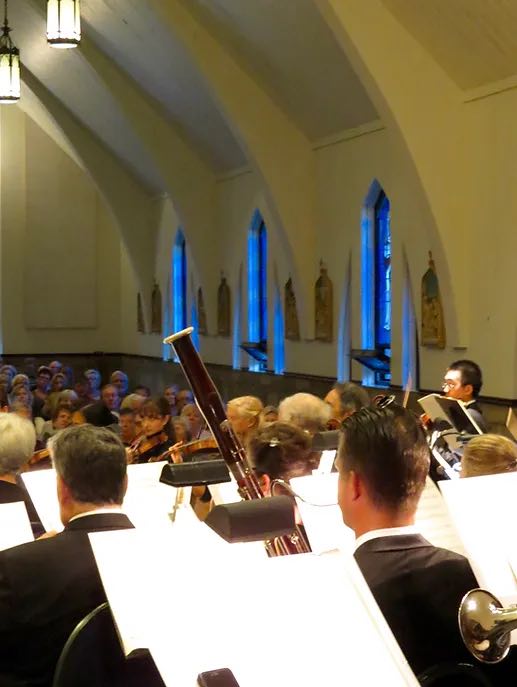 orchestra playing for audience sitting in pews