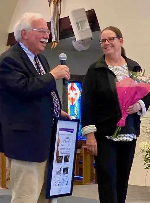 man holding a microphone and woman holding a bouquet of flowers