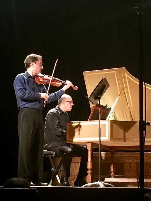 pianist and violinist playing on stage