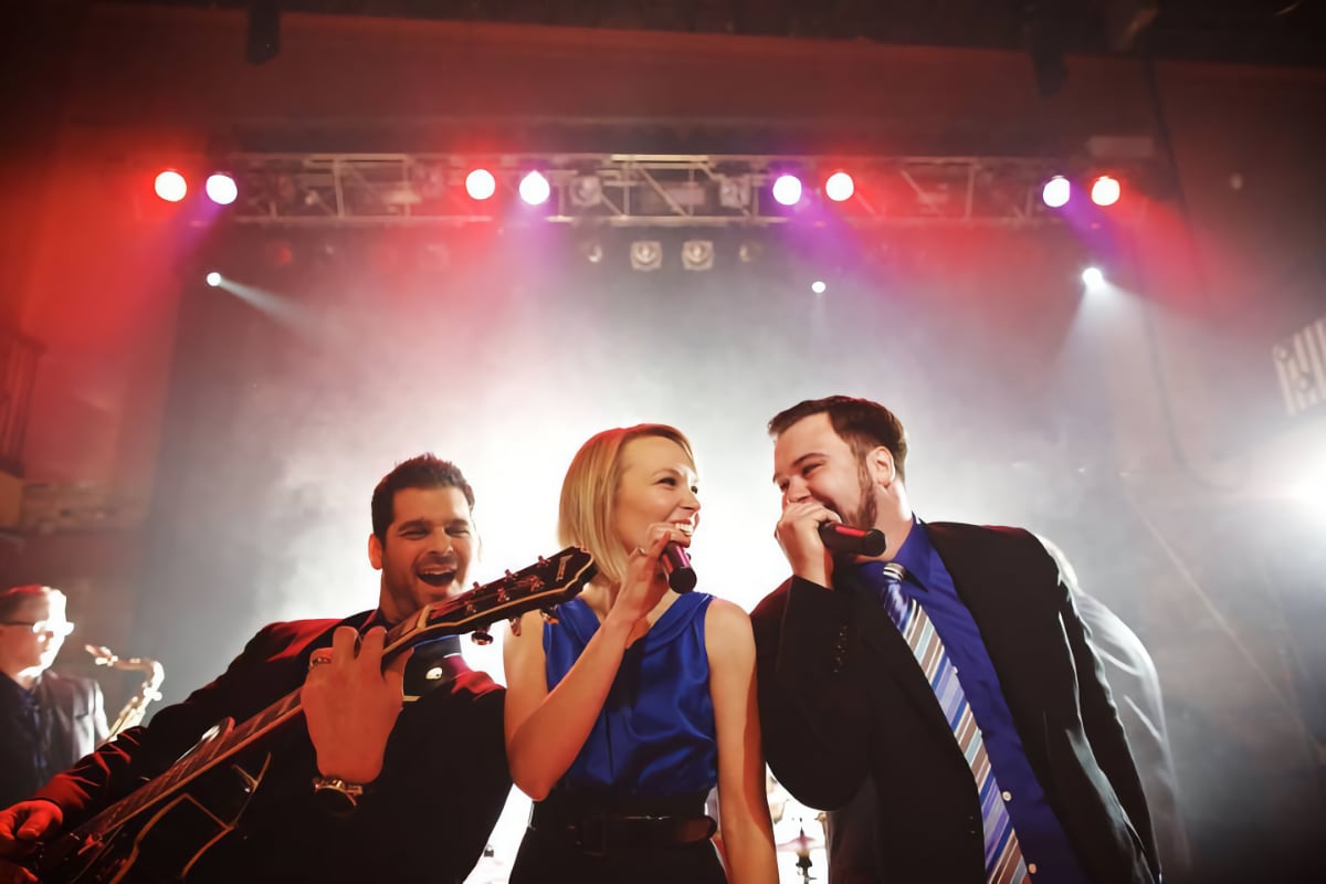 three members of Collision Six performing on stage