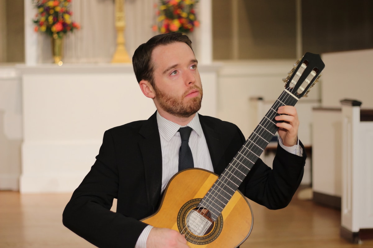 Colin Davin; musician holding a guitar