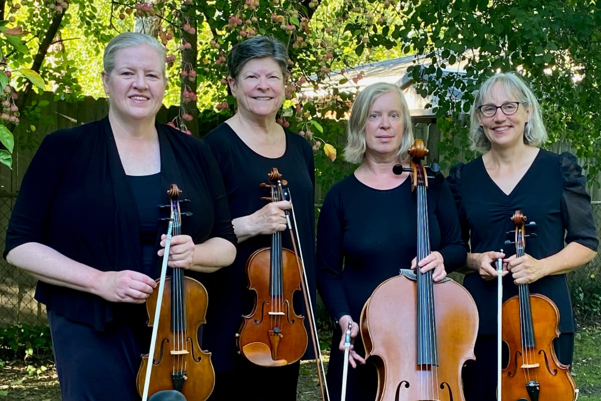 a quartet of women dressed in black holding their respective string instruments