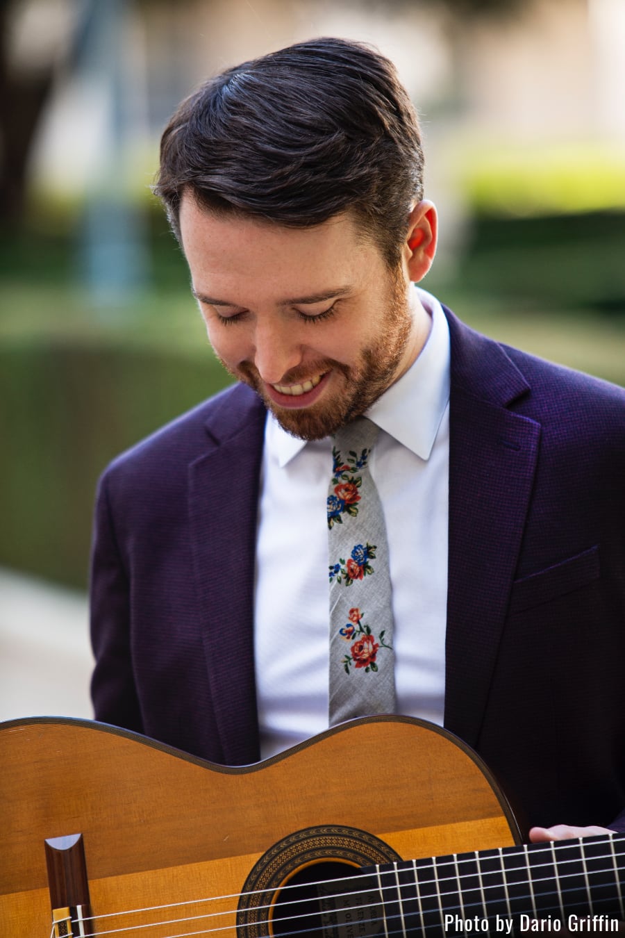 Musician Colin Davin smiling while looking down at his guitar; photo courtesy Dario Griffin