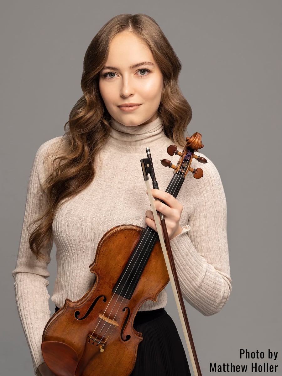 violinist Geneva Lewis in a beige turtleneck holding her violin; photo courtesy Matthew Holler